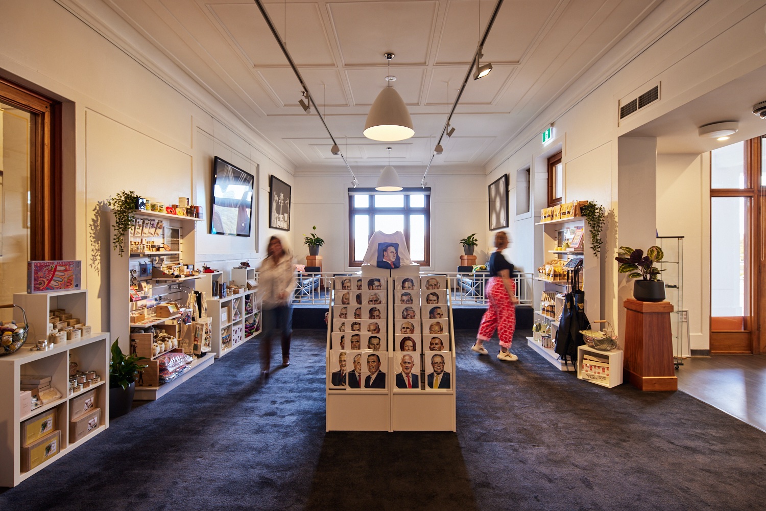 Some visitors shown as a blur walk around the MoAD shop and look at postcards, t-shirts and gifts. 