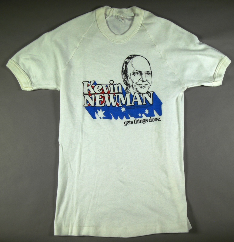 A white t-shirt with a caricature of a man's head, and the words 'Kevin Newman gets things done' with lettering shadow in the colours of the Australian flag.