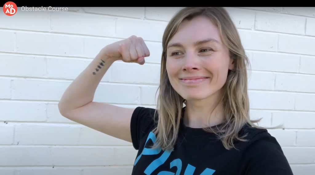 A PlayUP facilitator with her arm in the air.