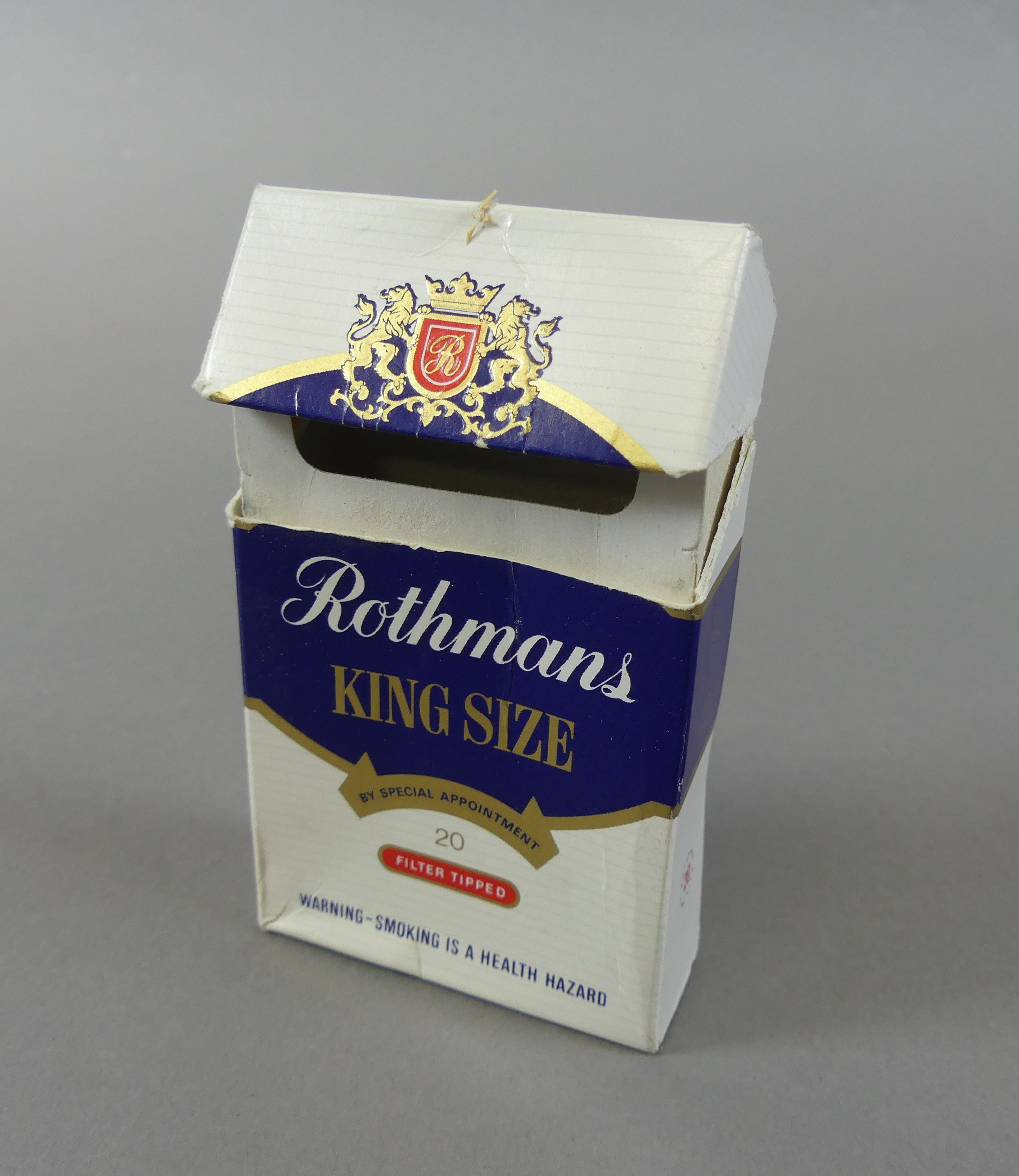 An empty cardboard packet of Rothmans king size cigarettes.