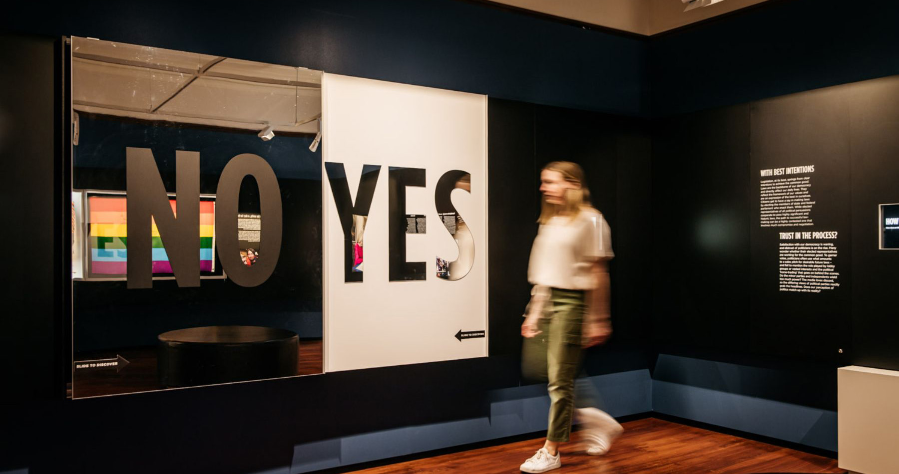 A visitor walking past a large "NO or YES" display