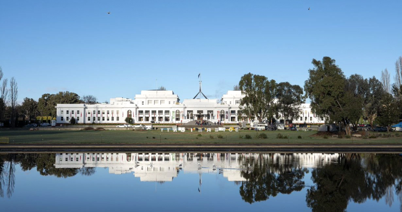 A view of Old Parliament House across the water, complete with reflection