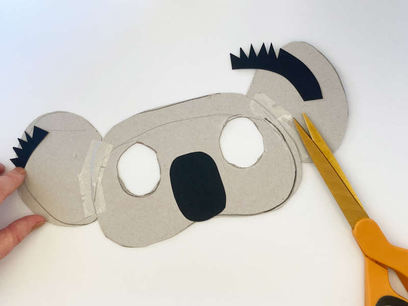 A koala mask with two eyes cut out, a black nose and black hair on the ears. 