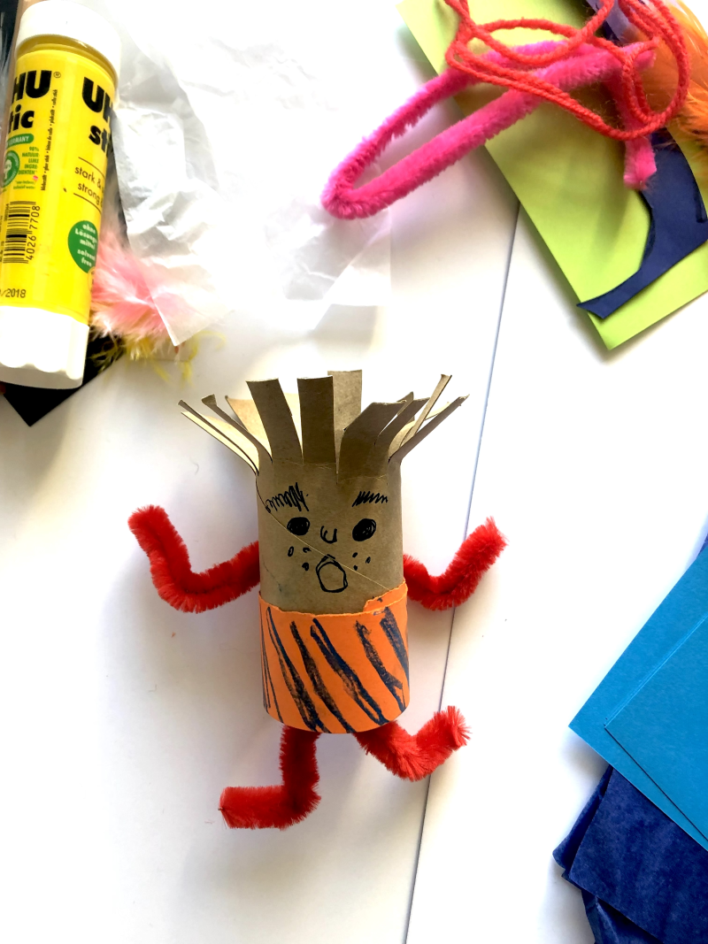 A toilet roll with the top cut into strips to represent hair and piper cleaner arms and a face drawn on.