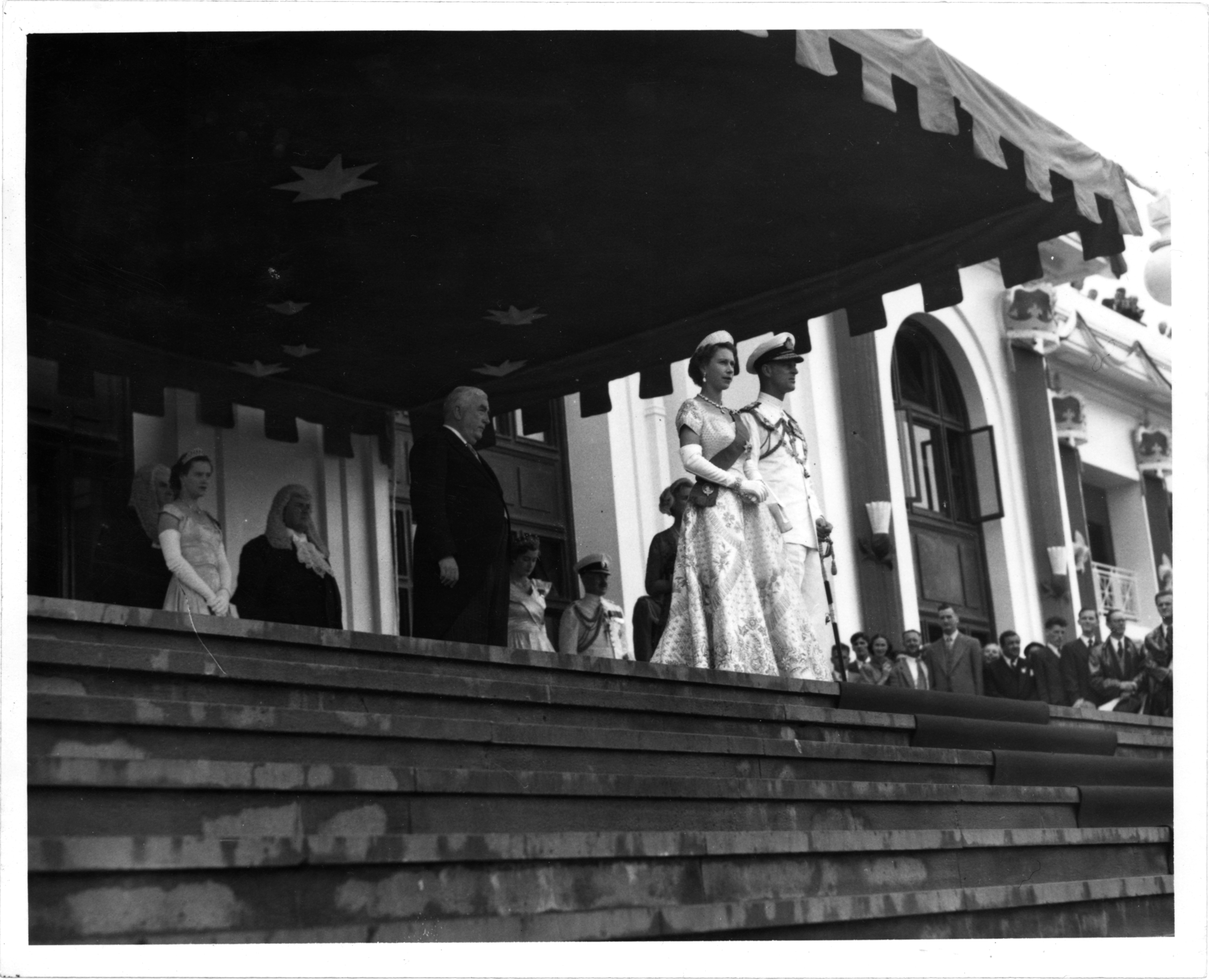 Black and white photograph of Queen Elizabeth II and Prince Philip standing at the front steps of (Old) Parliament House.