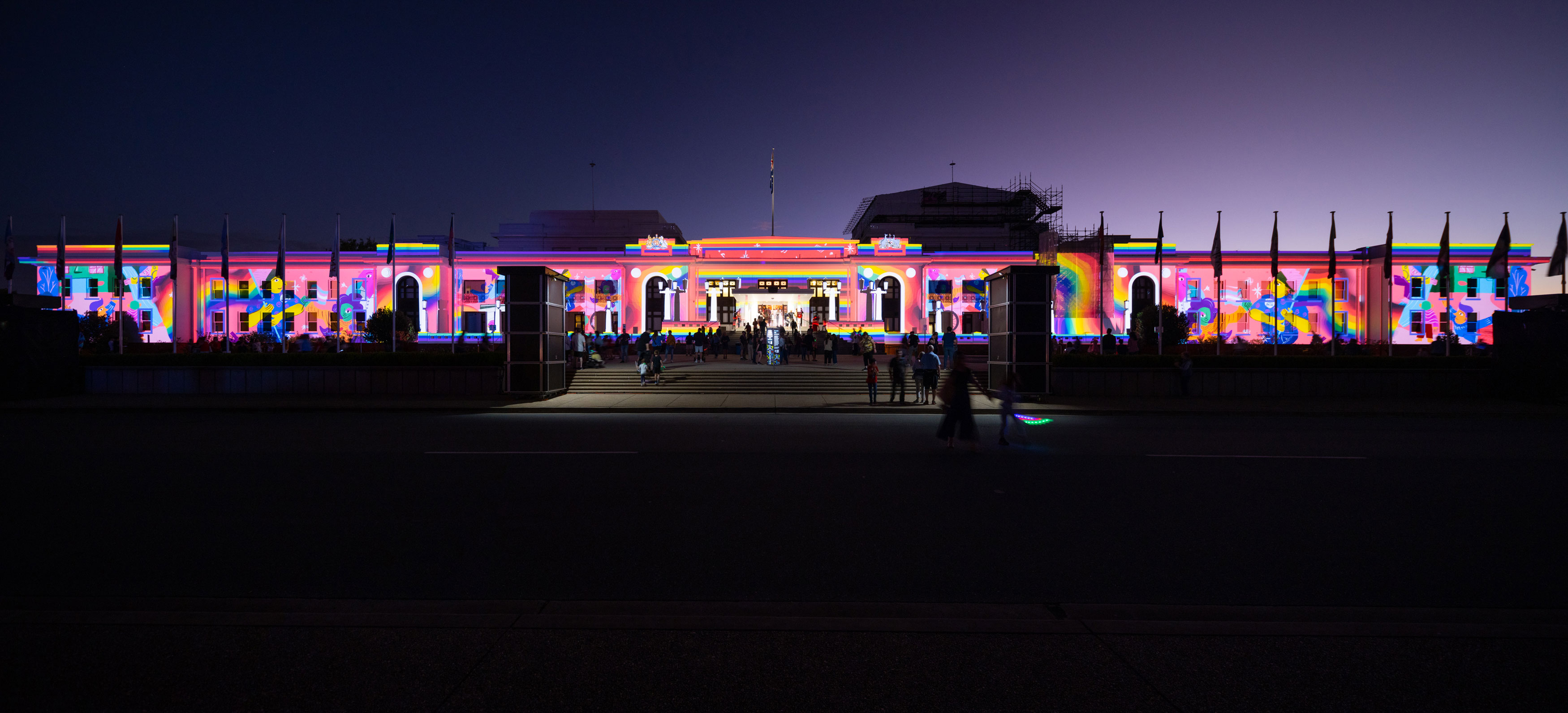 The outside of Old Parliament House at night lit up with colourful projections. 