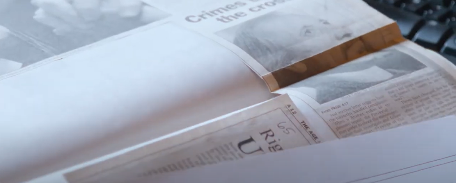 An open scrapbook with a newspaper article pasted into it. An open scrapbook with a newspaper article pasted into it.