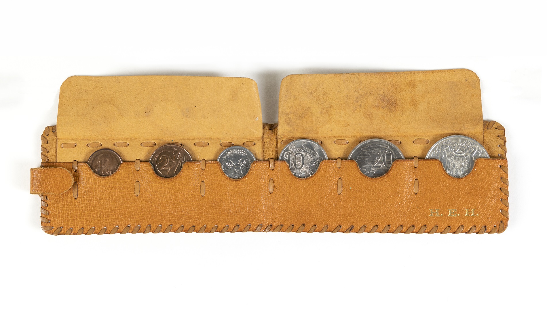 A leather pouch embossed with the letters H. E.H and holding a 1-cent, 2-cent, 5-cent, 10-cent, 20-cent and 50-cent coins