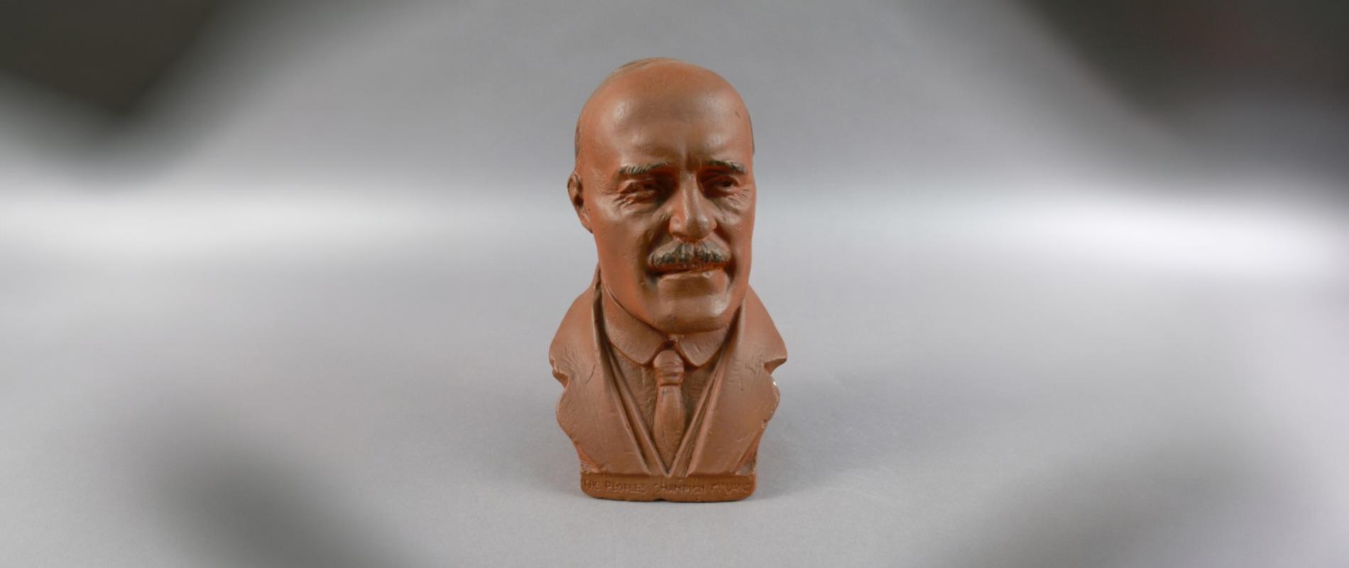 A terracotta clay bust of Jack Lang, wearing a tie and jacket lapels.