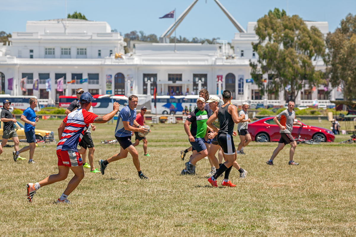 Football game being played on the lawn in front of Old Parliament House.