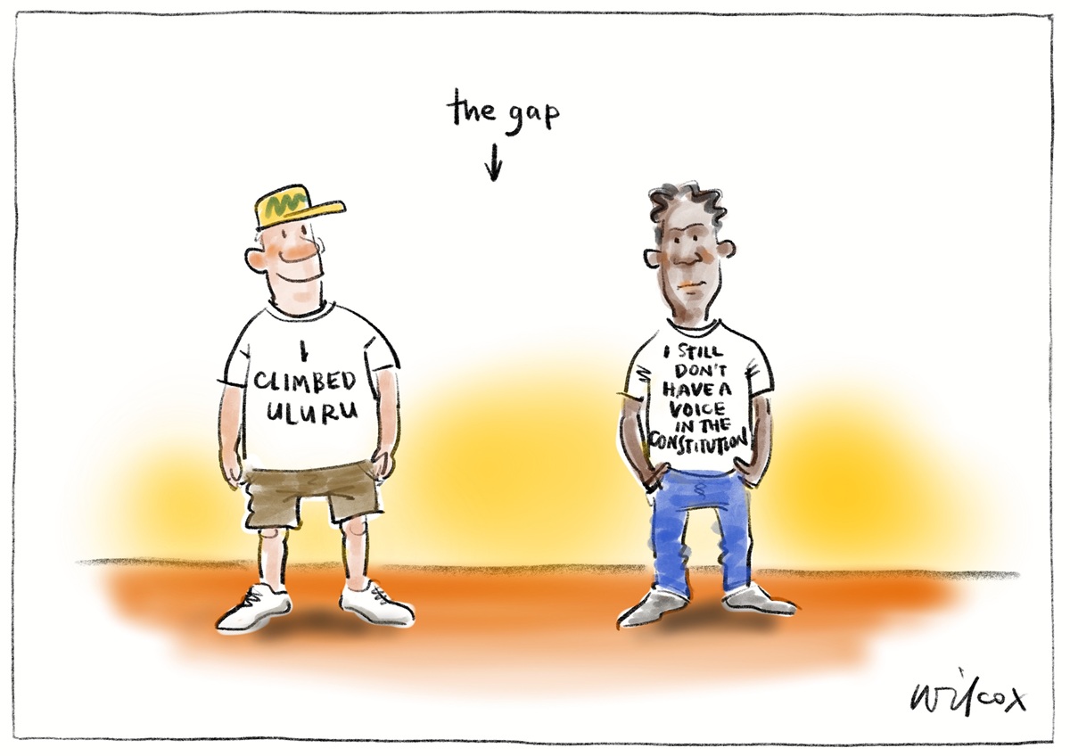 Two men stand with a gap between them. One man's T-shirt reads, 'I climbed Uluru'. Other man's T-shirt reads,  'I still don't have a voice in the Constitution'.