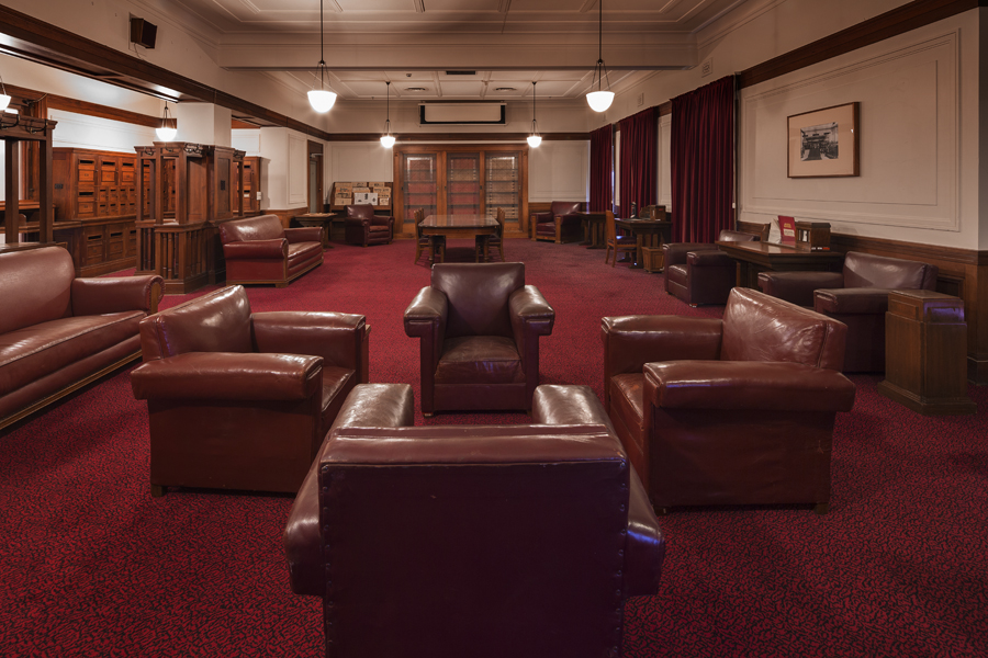 Red leather chairs and various wooden tables are arranged in the Senate Opposition Party Room in Old Parliament House.