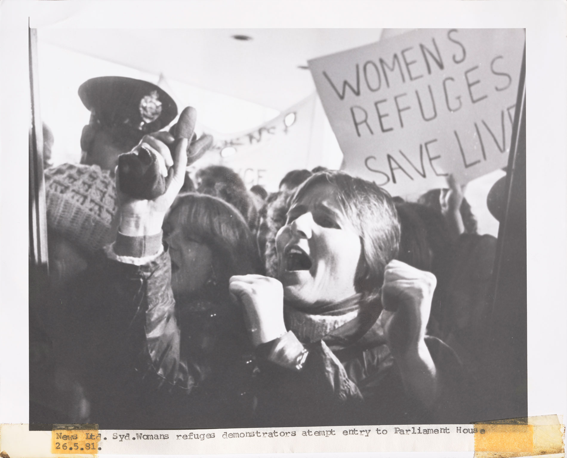 A woman demonstrates in a crowd outside Parliament House. A woman demonstrates in a crowd outside Parliament House.