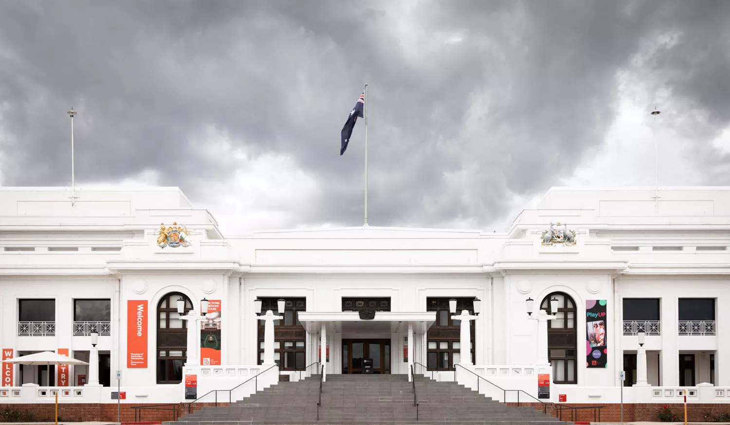 A large staircase leads up to a white old building with a flag on the top. A large staircase leads up to a white old building with a flag on the top.
