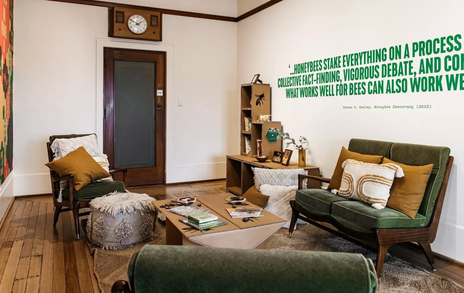 A room with green couches, cushions on the floor and books on the bookshelf. A room with green couches, cushions on the floor and books on the bookshelf.
