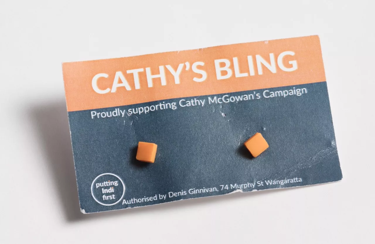 Photograph of two orange square earrings attached to a card with the lablel "CATHY'S BLING - Proudly supporting Cathy McGowan's Campaign"