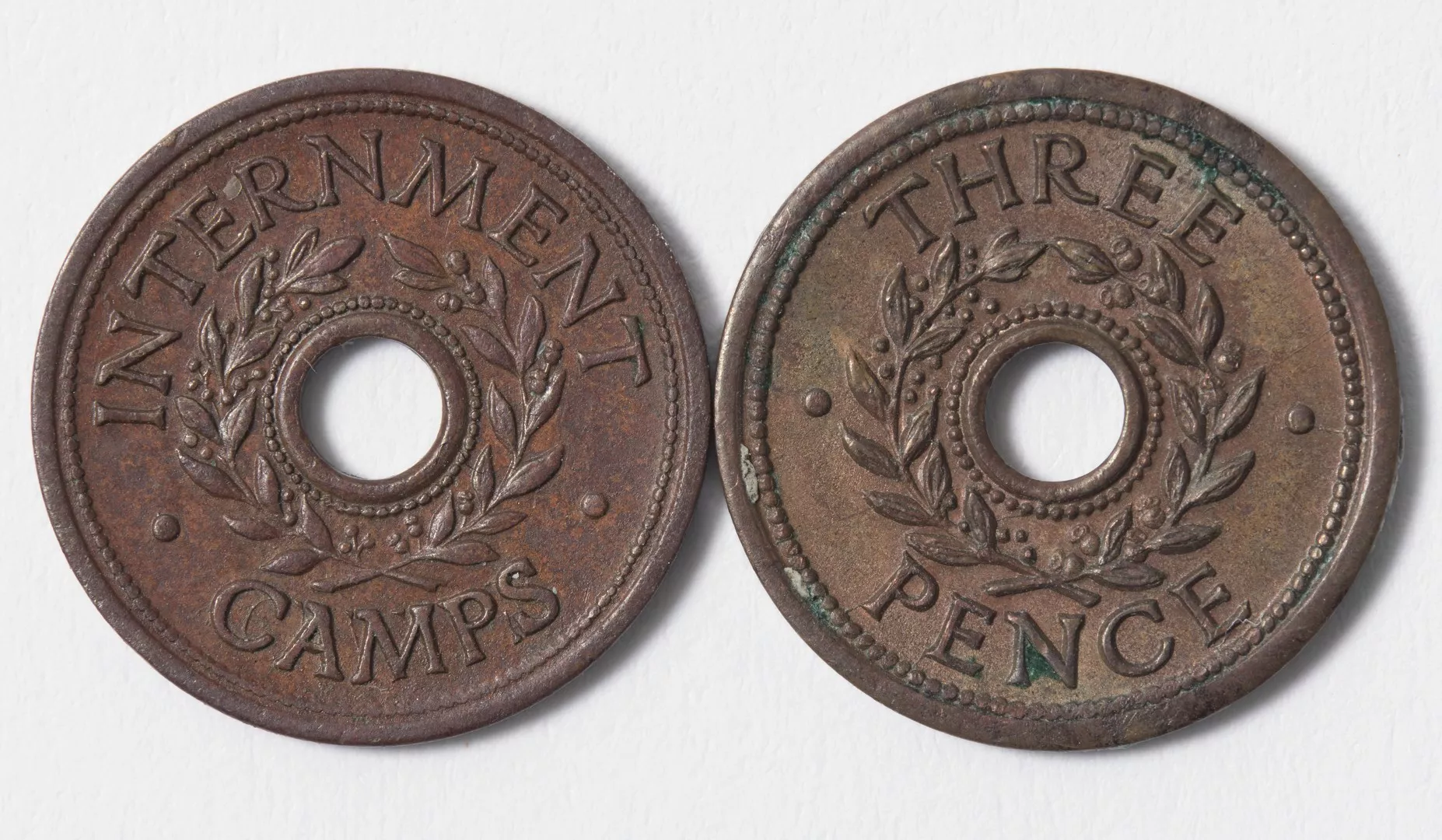 Photograph of two threepenny internment camp tokens.jpg