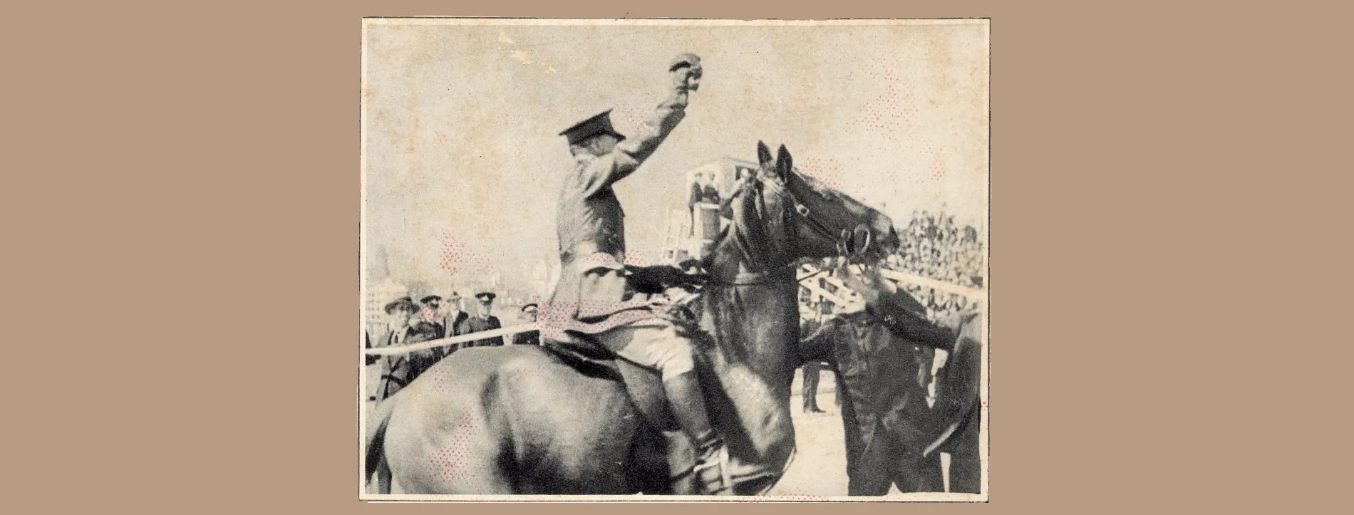 Black and white published photo of Francis de Groot, in uniform, sitting on a horse, sword raised, surrounded by people.