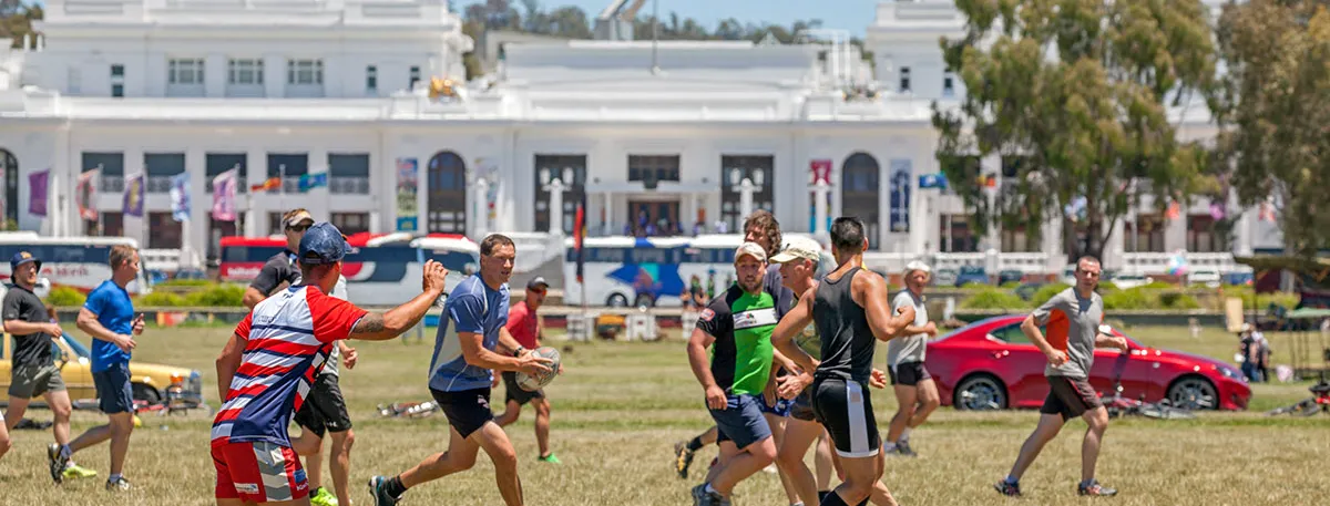 Football game being played on the lawn in front of Old Parliament House.