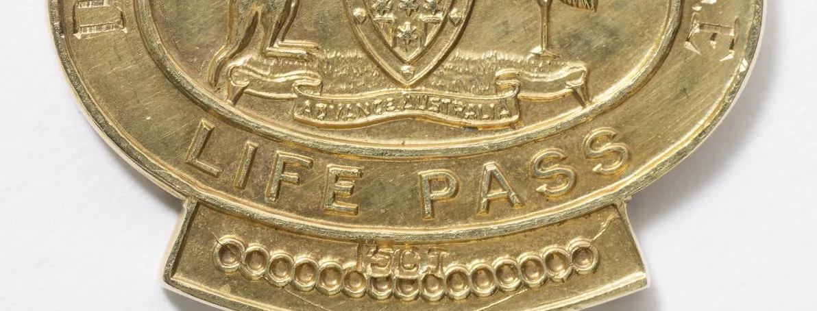 One side of a gold pocket-sized medallion with a crown at the top and the text 'Dame Dorothy Tangney D.B.E.' and 'Life Pass' around the Commonwealth Coat of Arms.