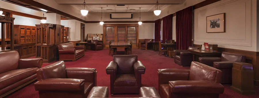Red leather chairs and various wooden tables are arranged in the Senate Opposition Party Room in Old Parliament House.