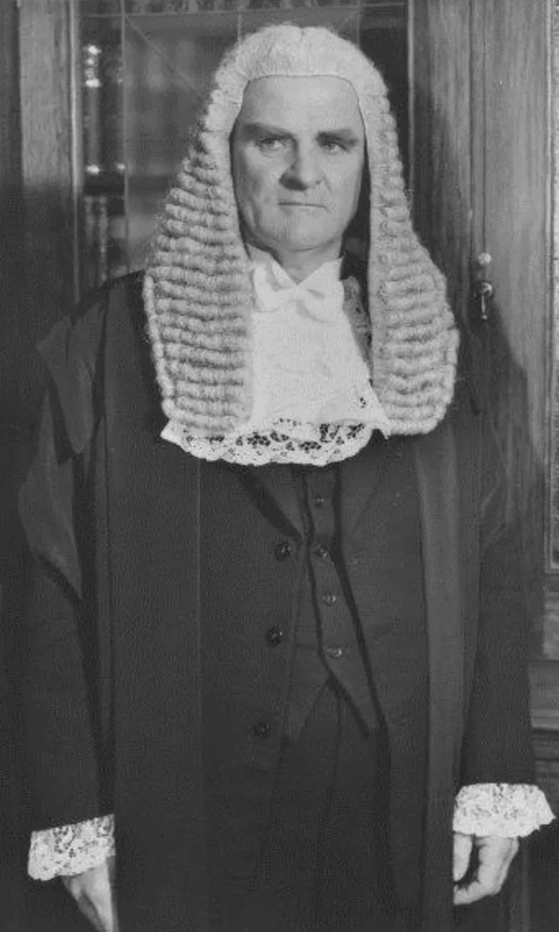 Speaker of the House, Archie Cameron, wearing a black ceremonial attire and wig.