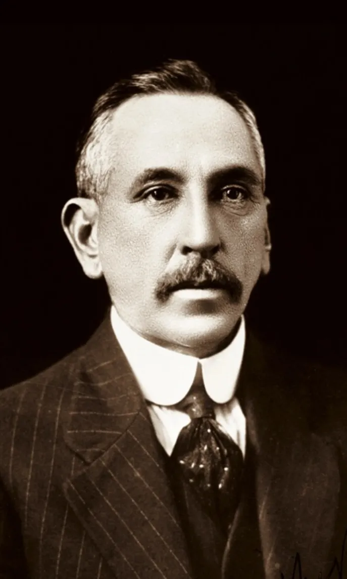 Portrait photograph of Billy Hughes, wearing a pin-striped suit.