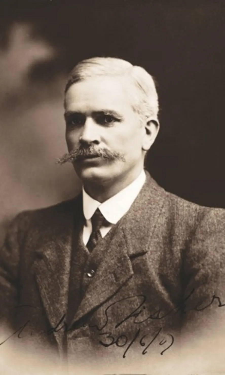 Black and white portrait photograph of Andrew Fisher, wearing a three-piece suit and sporting a long moustache.