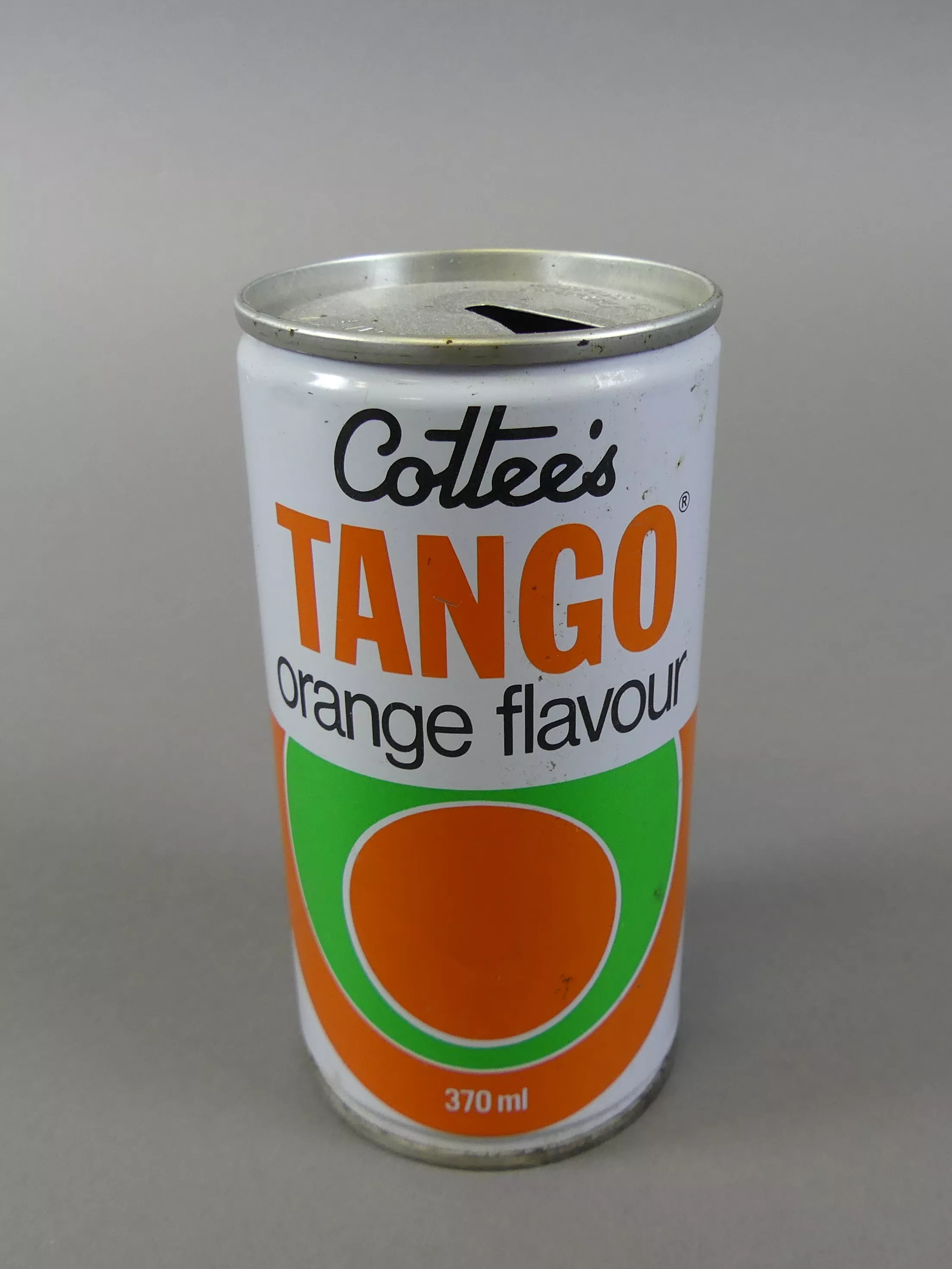 A drink can with a white, orange and green coloured pattern, labelled 'Cottee's Tango Orange Flavour, 370ml'.