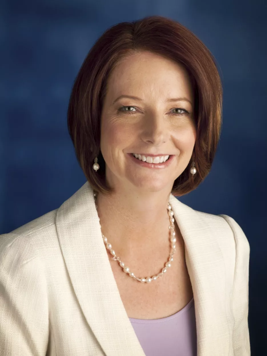 Julia Gillard wearing a pearl necklace and earrings and a white jacket.