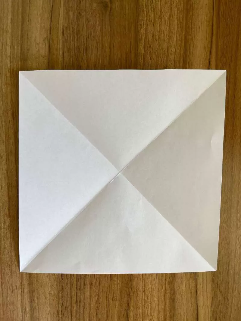 A square piece of paper with diagonal creases. A square piece of paper with diagonal creases.