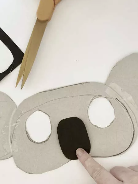 A koala mask with two eye holes cut out and a black nose. A koala mask with two eye holes cut out and a black nose.