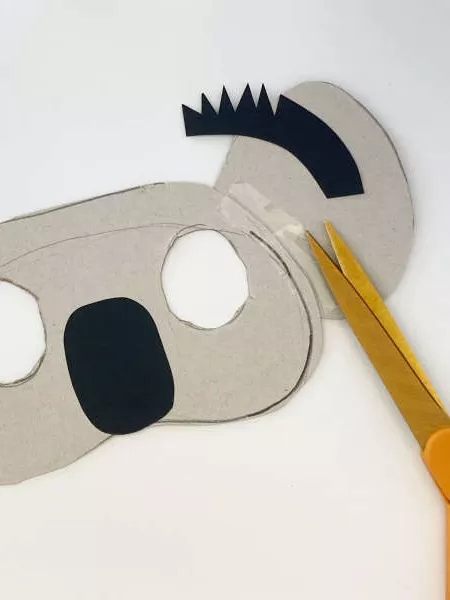 A koala mask with two eyes cut out, a black nose and black hair on the ears. A koala mask with two eyes cut out, a black nose and black hair on the ears.