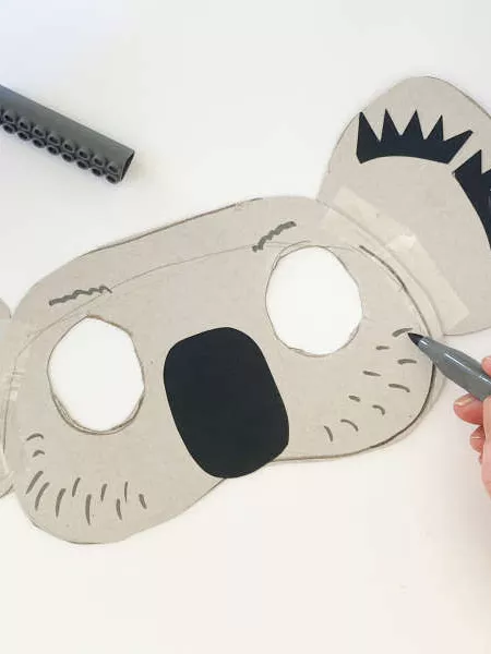 A koala mask with eyes cut out, black nose, black ears. 