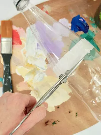 A paint palette, a plastic bottle, paint brushes and a little herb pot. 