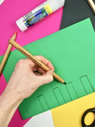 A green piece of paper with 4 small rectangles drawn along the bottom. A green piece of paper with 4 small rectangles drawn along the bottom.