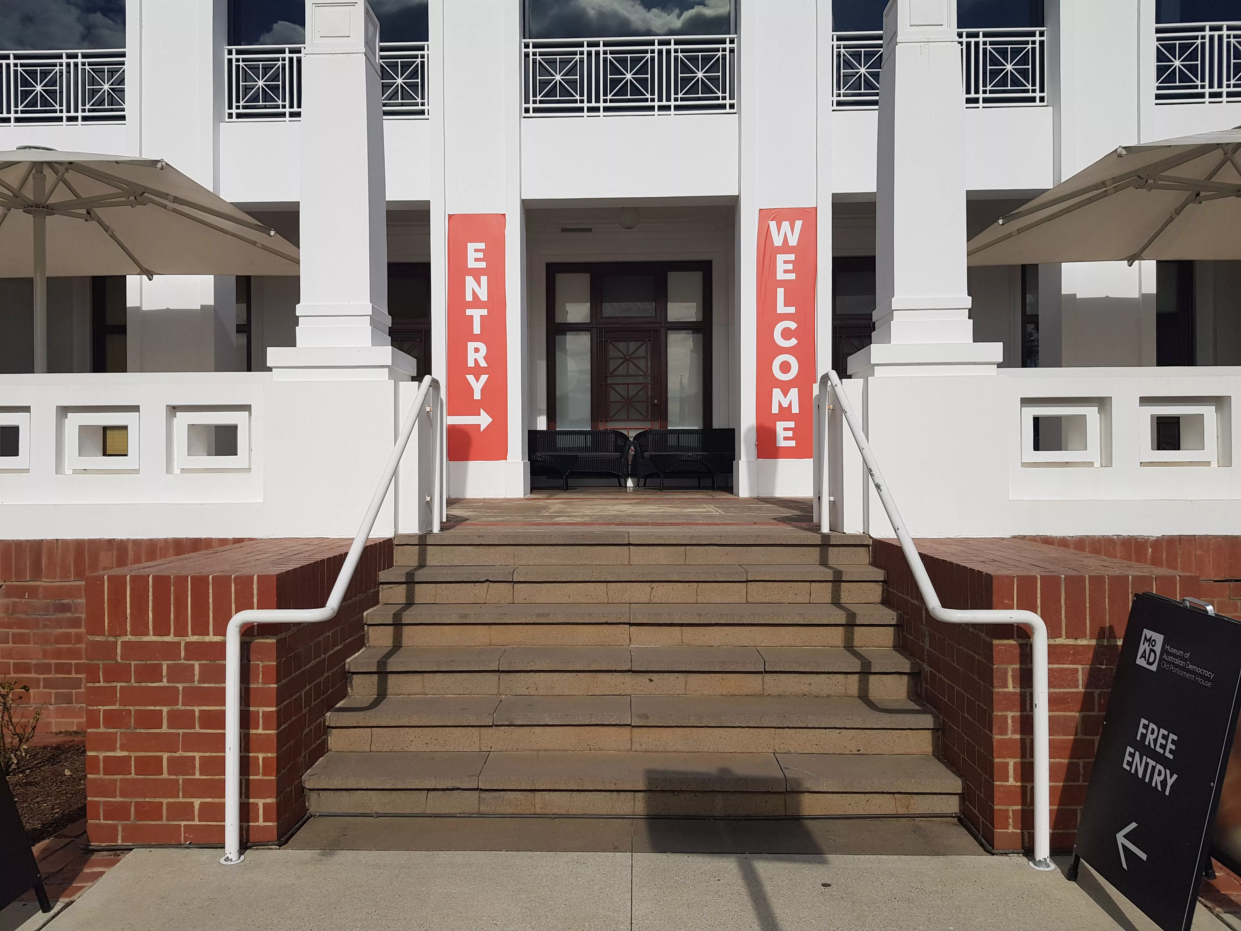 Stairs leading up to a white building with red banners and the signs 'Welcome'. Stairs leading up to a white building with red banners and the signs 'Welcome'.