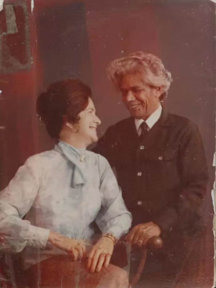 Worn and faded photograph of Heather and Neville Bonner, sitting together and smiling at each other.