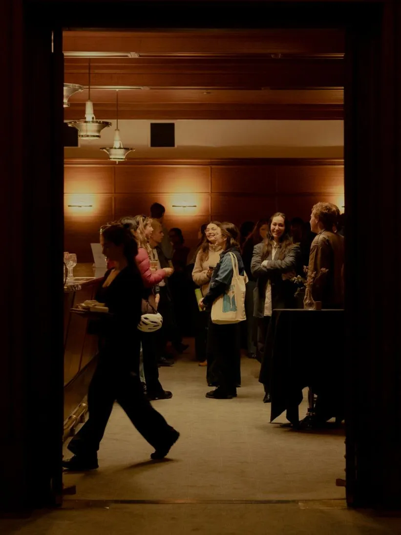 People gathered in the Members' Bar at Old Parliament House, the room is warmly lit and bustling with activity.