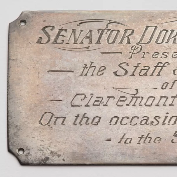 Photograph of a metal plaque labled "SENATOR DORTHOY TANGNEY. Presented by the Staff and Children of the Claremont School, W.A. On the occasion of her election to the Senate. Aug 1st 1943."