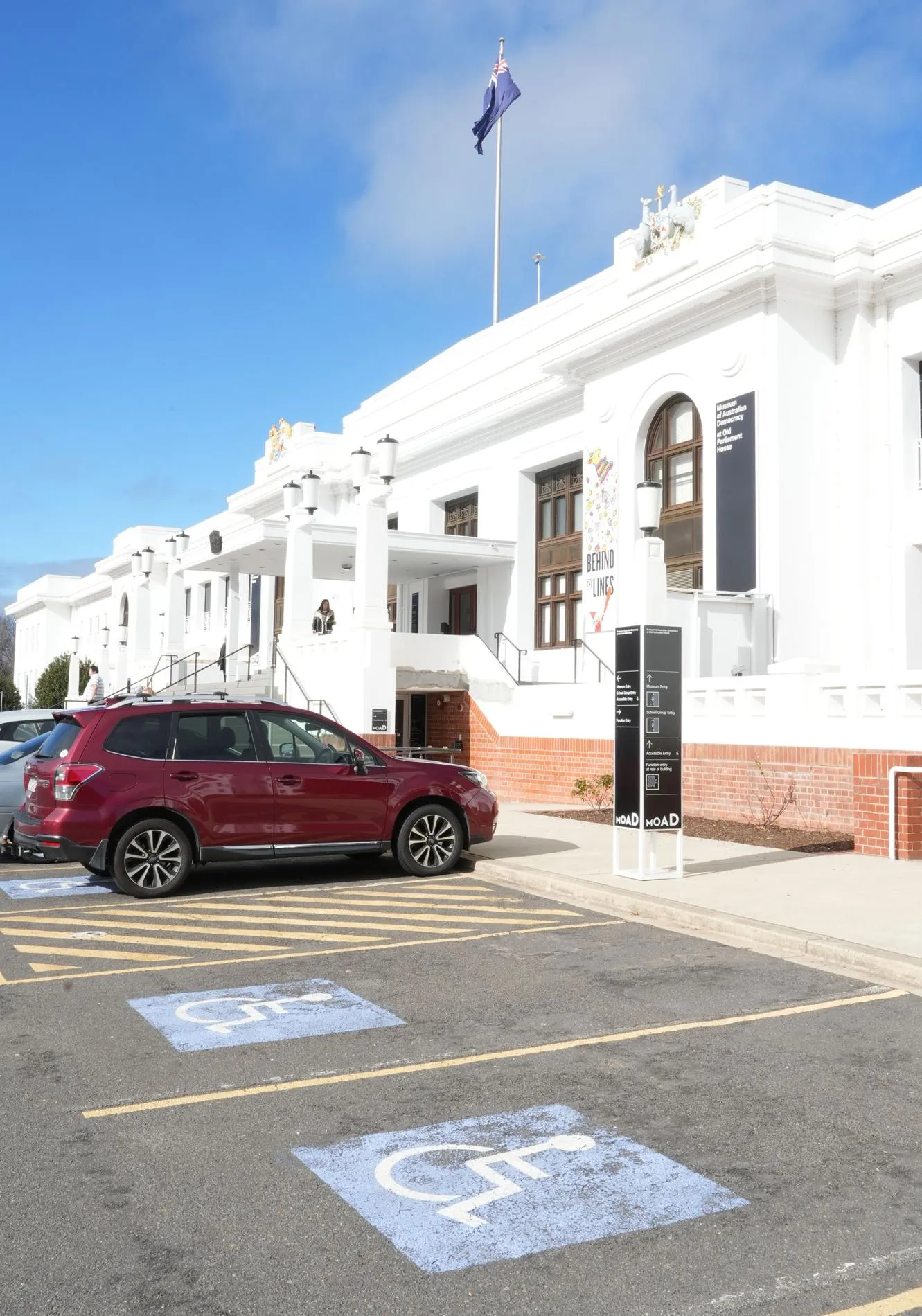 Accessible parking and cars in parking bays outside MoAD at Old Parliament House.