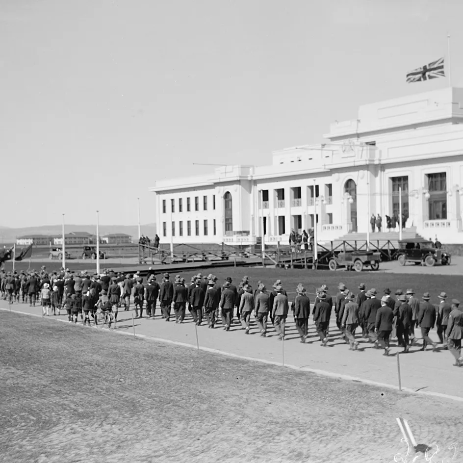 A parade marches in front of Parliament House. 