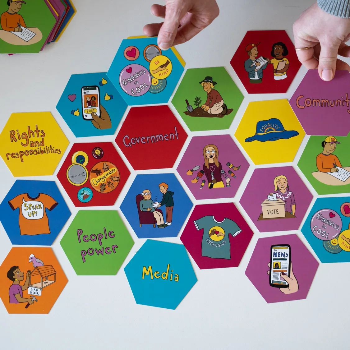 Hexagonal coloured tiles featuring words about civics and democracy.