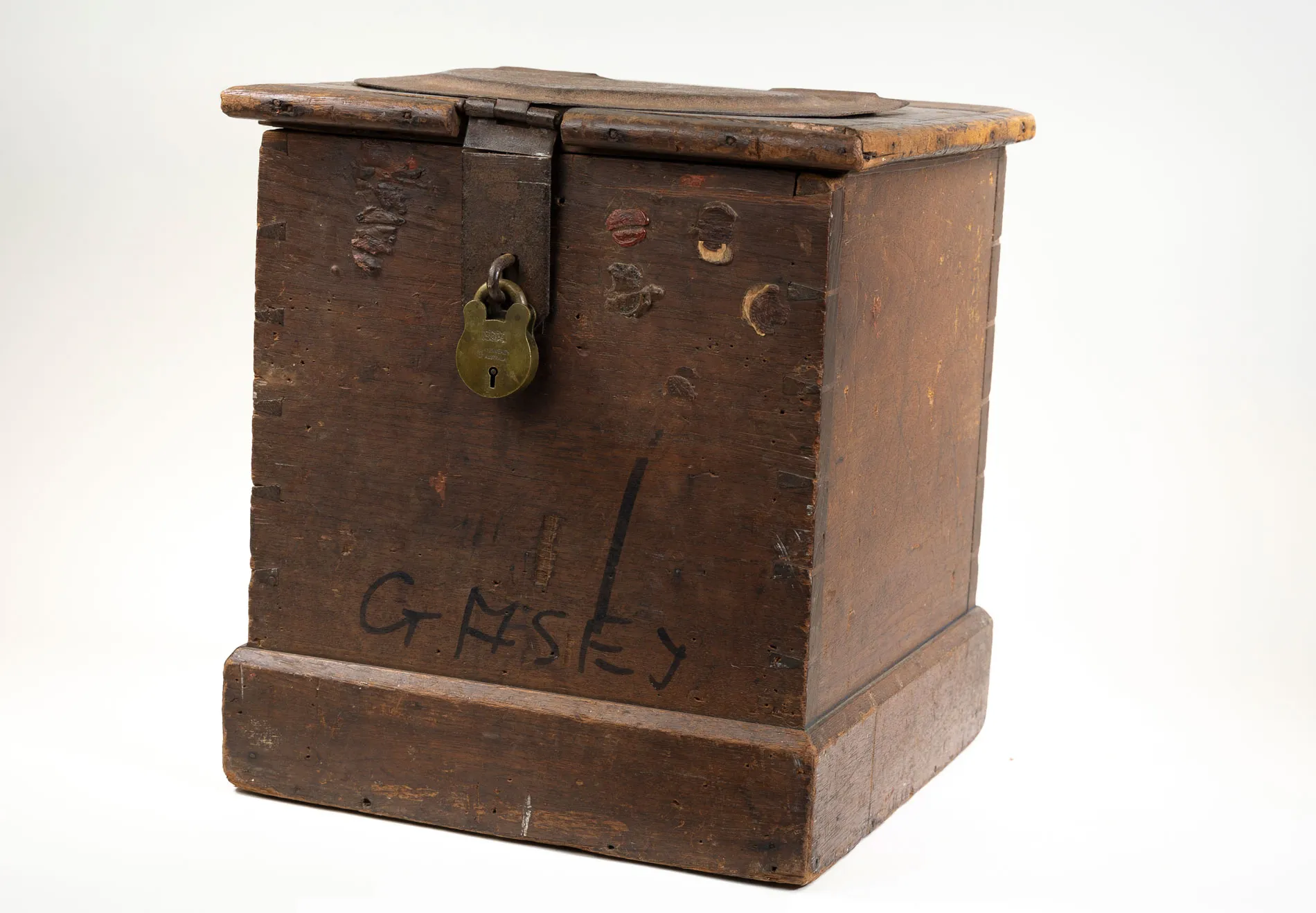 An old-fashioned wooden ballot box with a aged bronzed padlock on the front.