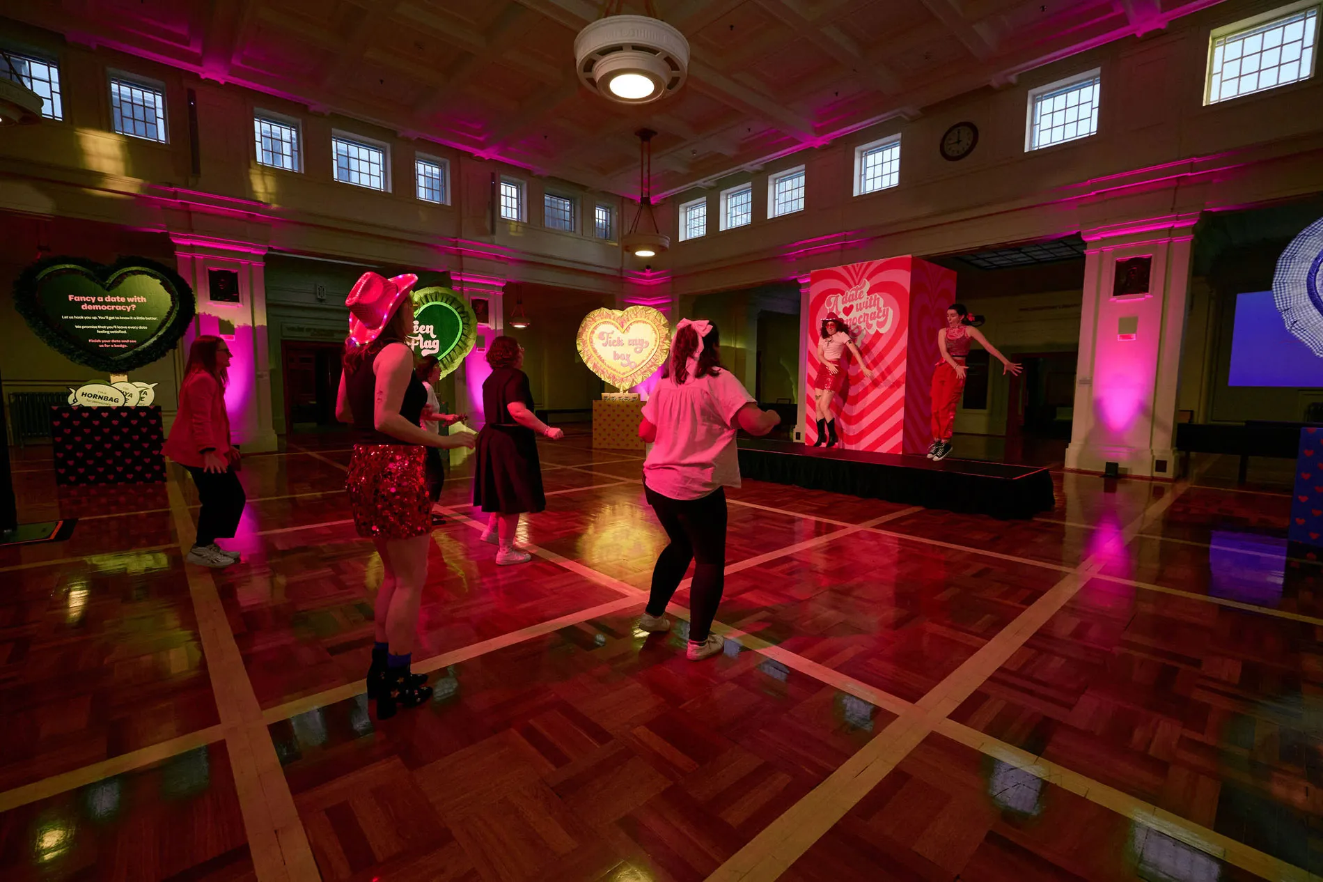 People dance in King's Hall in Old Parliament House. There are giant love hearts around the dancefloor.